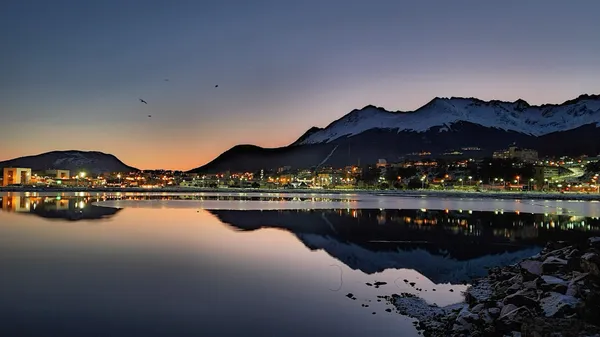 Ciudad de Ushuaia con montañas al atardecer